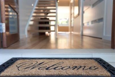 welcome mat in front of open door to hoe