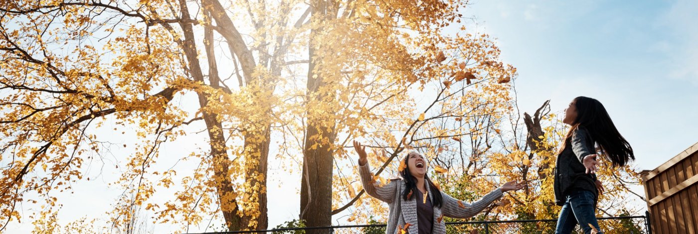 mother and daughter playing in leaves