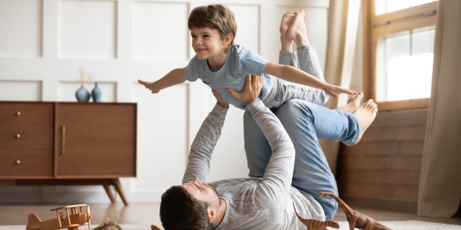 father and son playing together at home