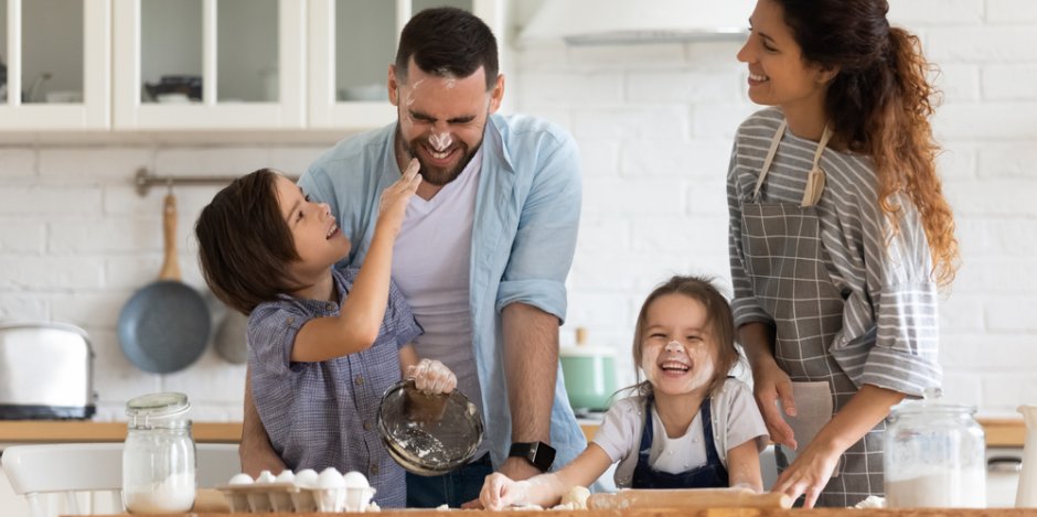 family of four in kitchen at home baking together