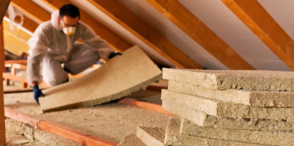 new insulation being installed in attic of home