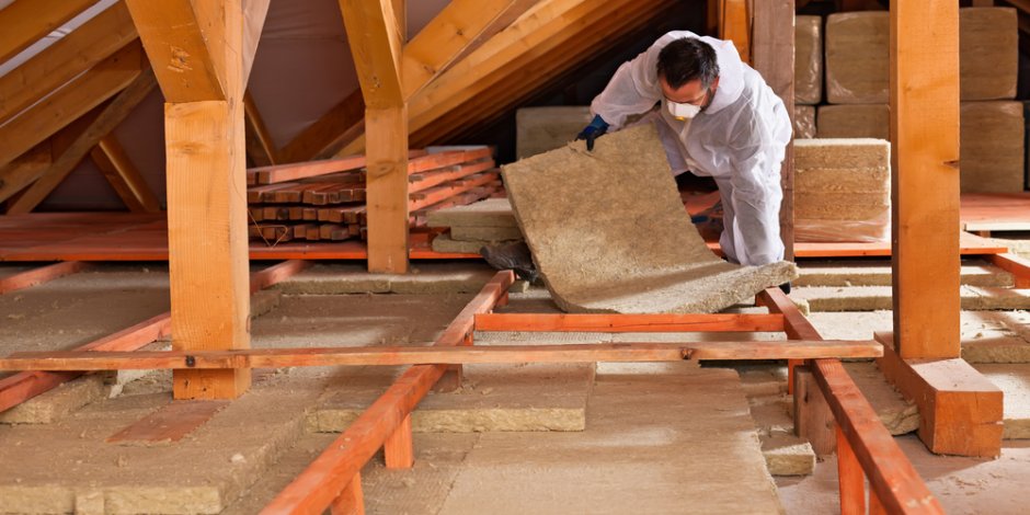 technician installing insulation in attic