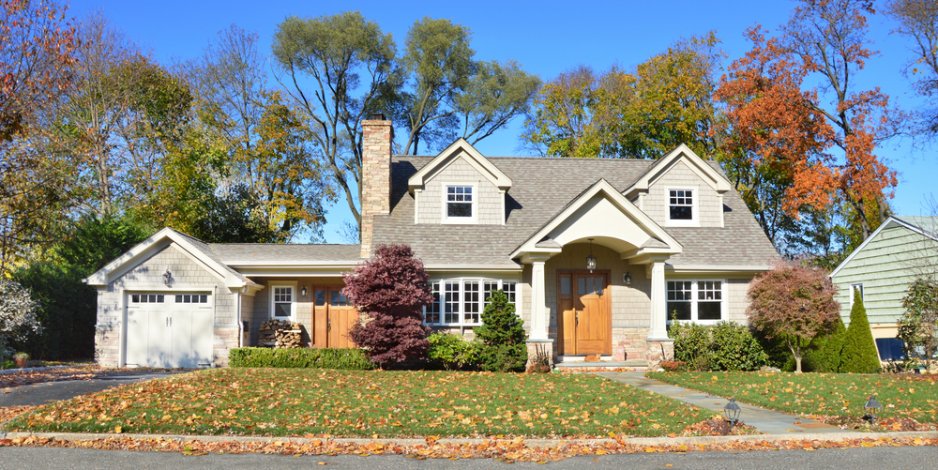 suburban house against autumn trees and blue skies